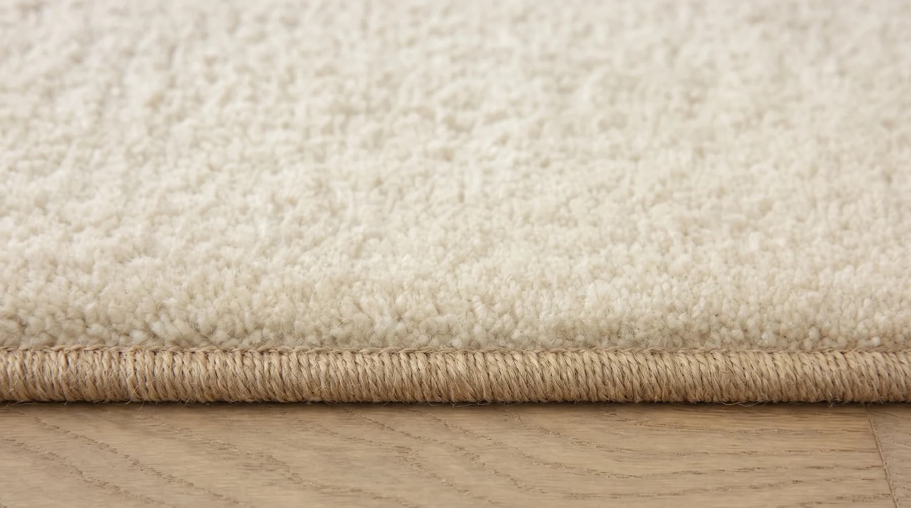 Cut-pile carpet with a serged bound edge