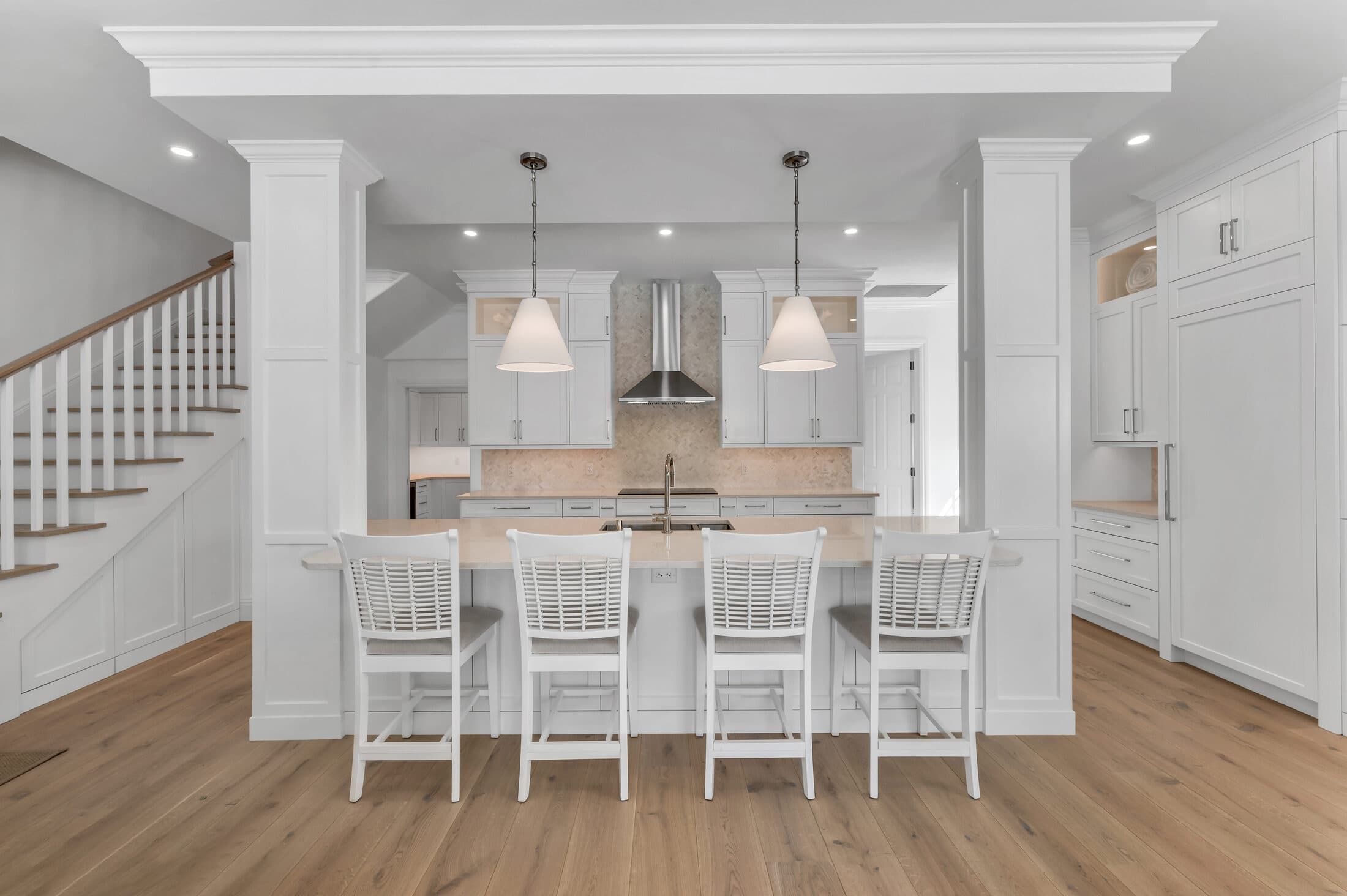 A bright Old Naples kitchen ProFloors installed — white cabinetry and quartz counters running column to column