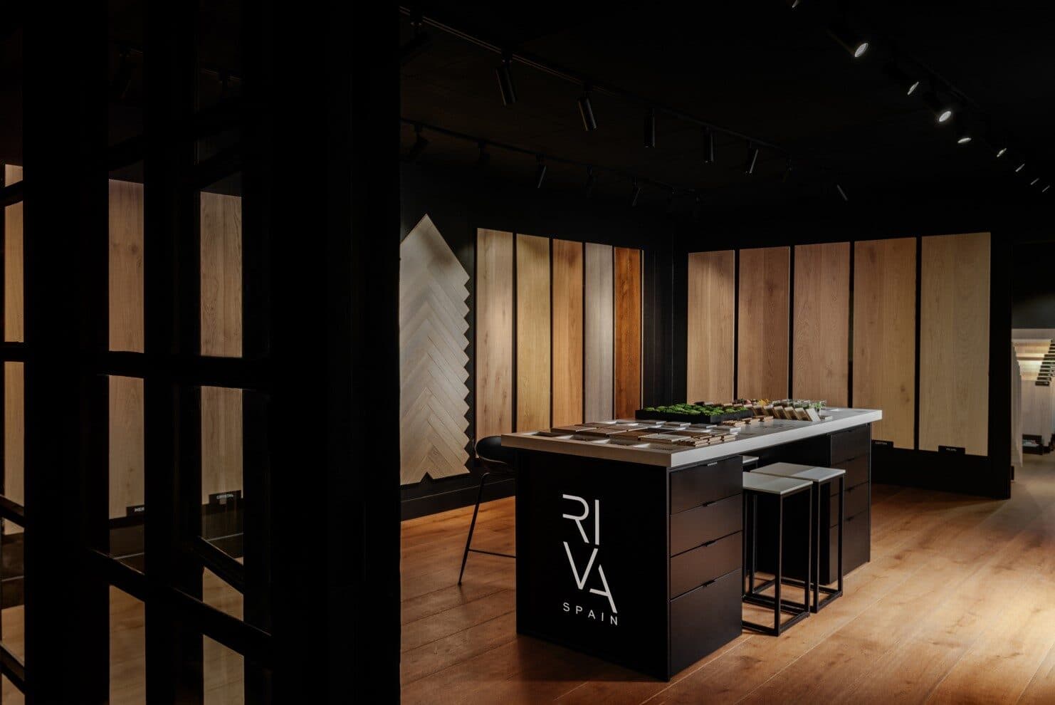 A RIVA Spain display gallery — tall wide-plank and herringbone European white oak panels around a RIVA Spain sample island