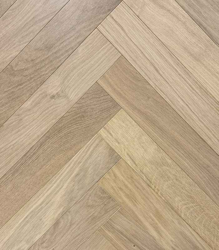 RIVA Crystal European white oak laid in herringbone pattern, grain reversing at each angular join so light reads every block differently