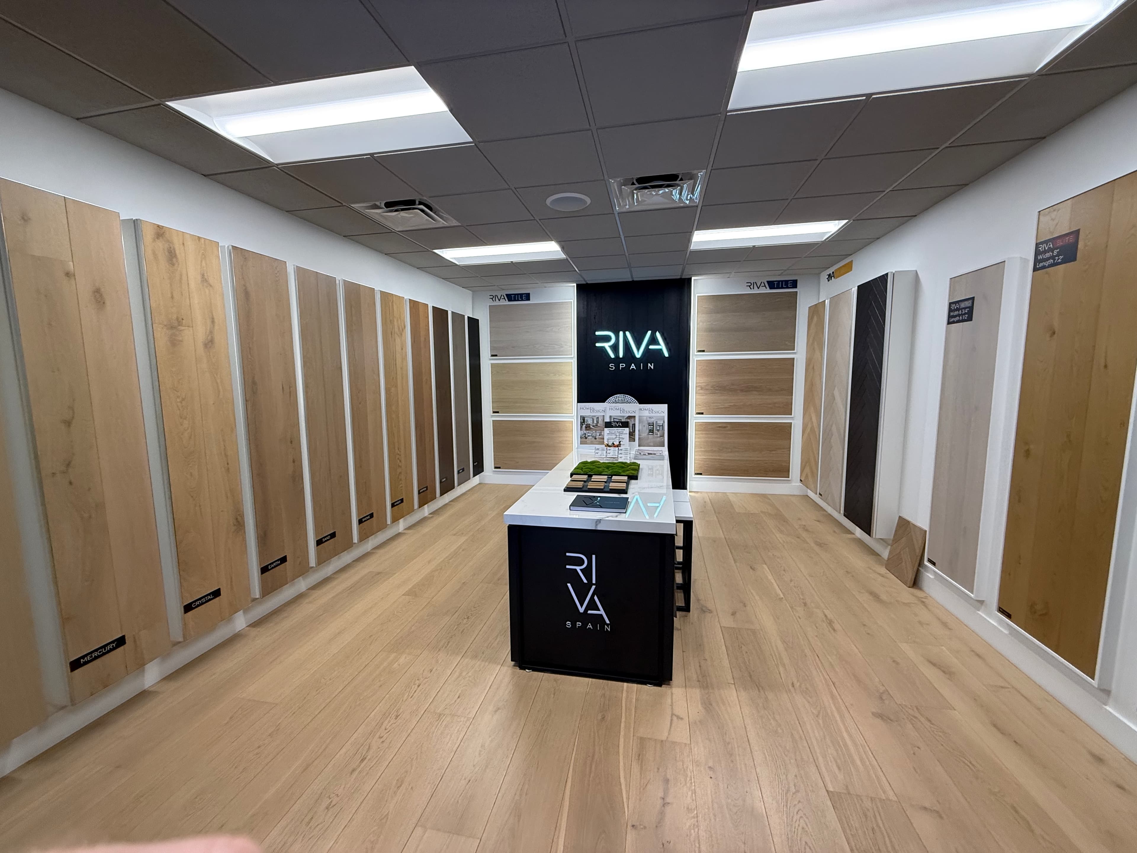 The RIVA Spain room at the ProFloors Naples showroom — full-height oak plank walls around a design table