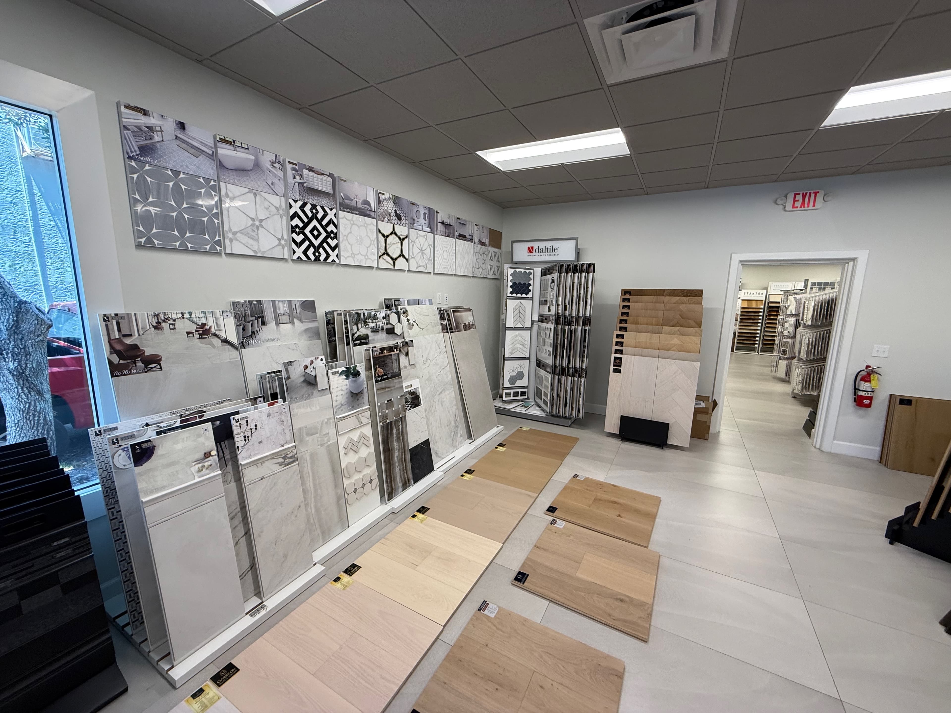The stone and decorative-mosaic wall in the ProFloors Naples showroom, boards mounted at eye level