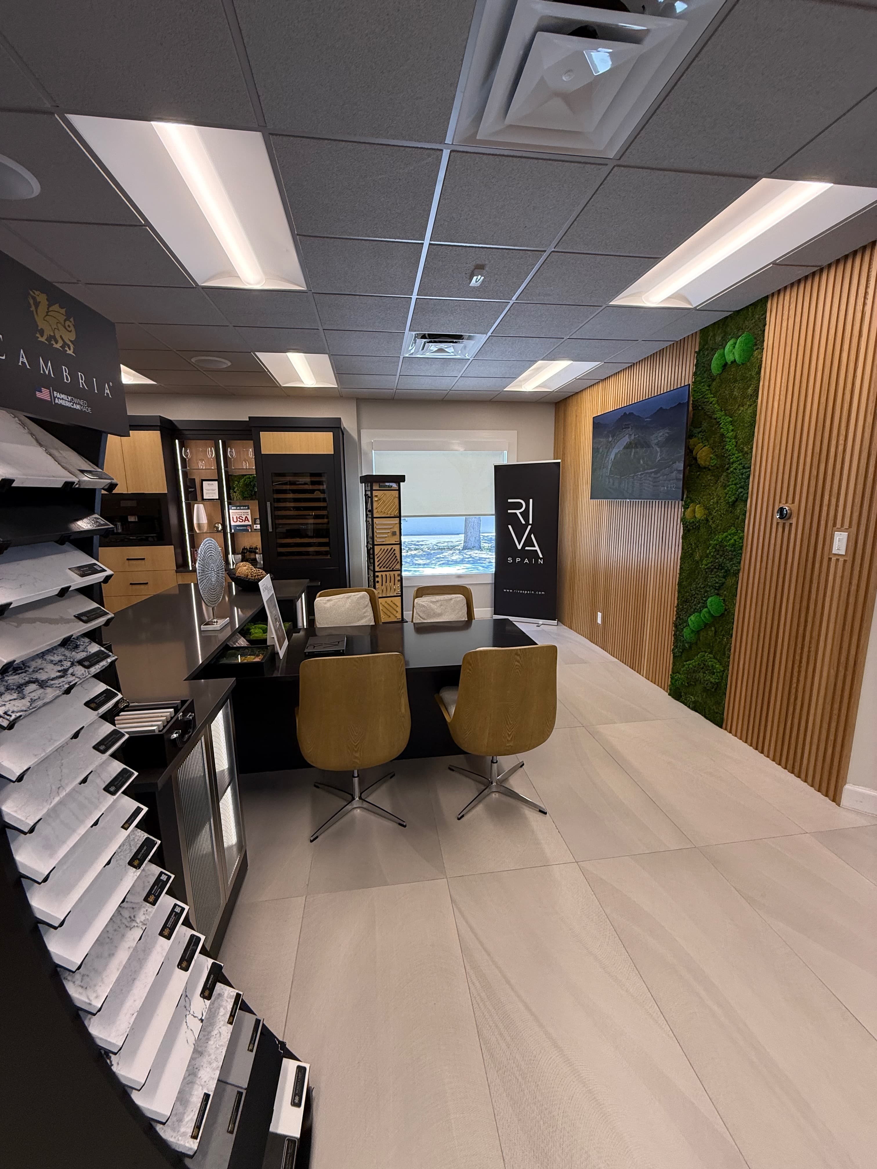 A designer consultation at the ProFloors showroom in front of the Cambria moss display wall.