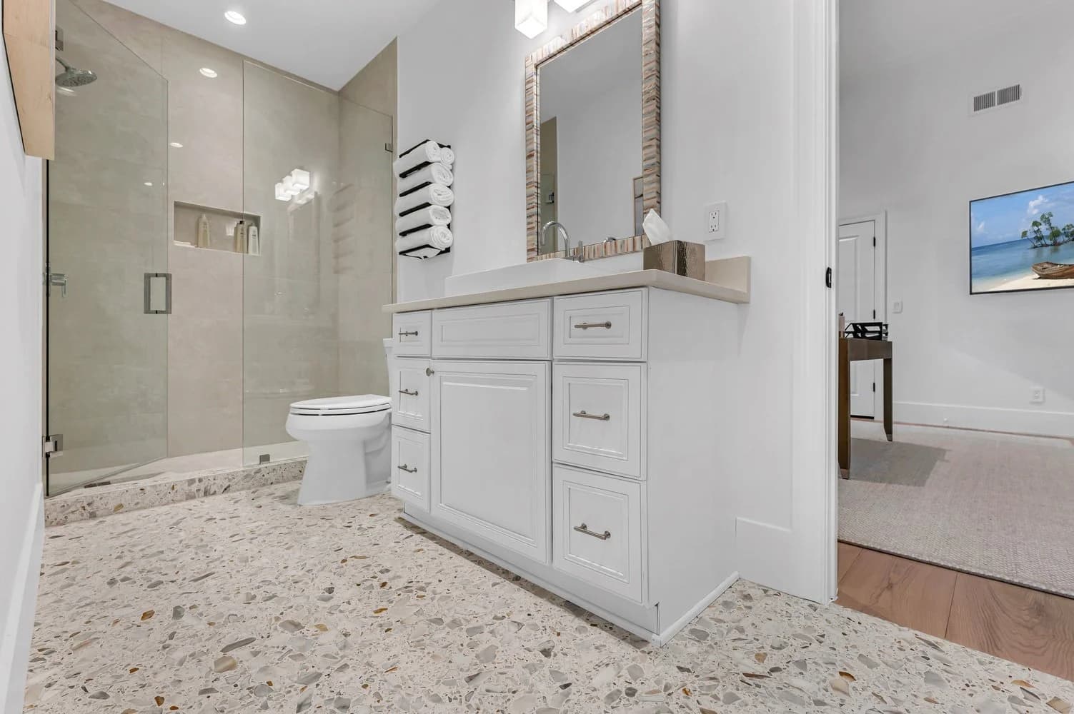 A finished Naples walk-in shower — large-format porcelain walls and a curbless terrazzo floor, waterproofed and flood-tested before a single tile was set