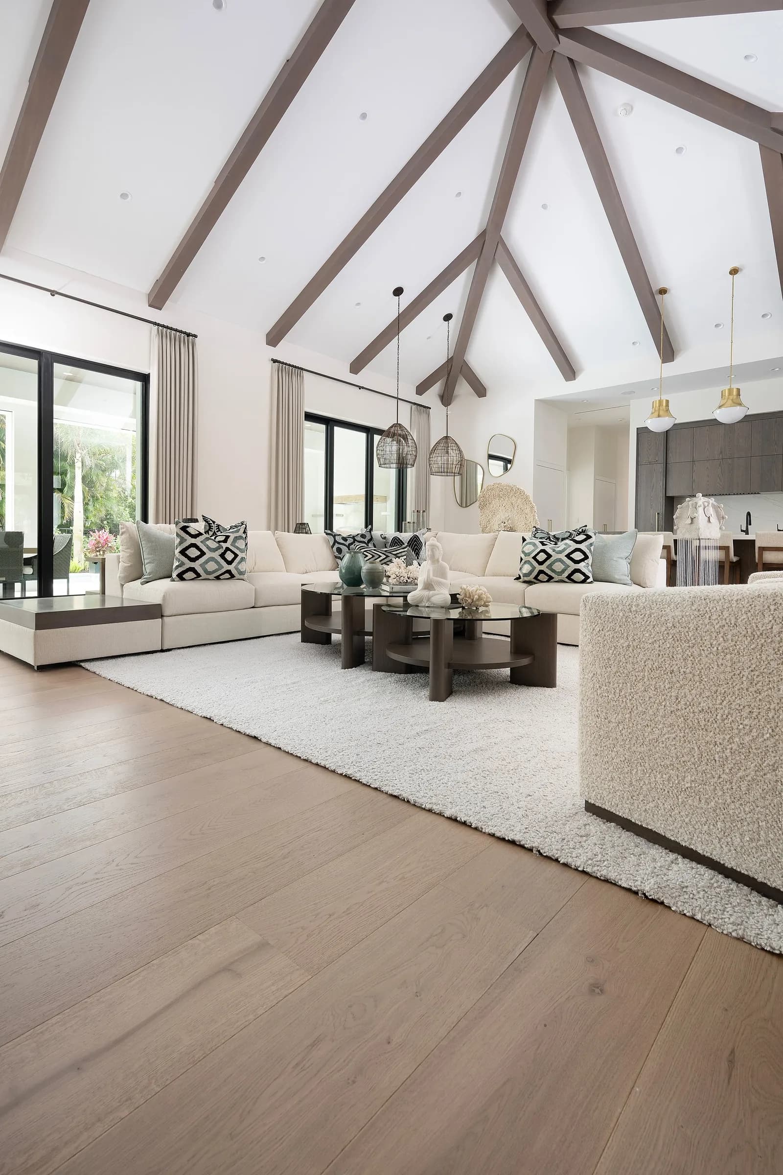 Wide-plank European white oak floor sweeping across a vaulted Naples great room with three sides of glass