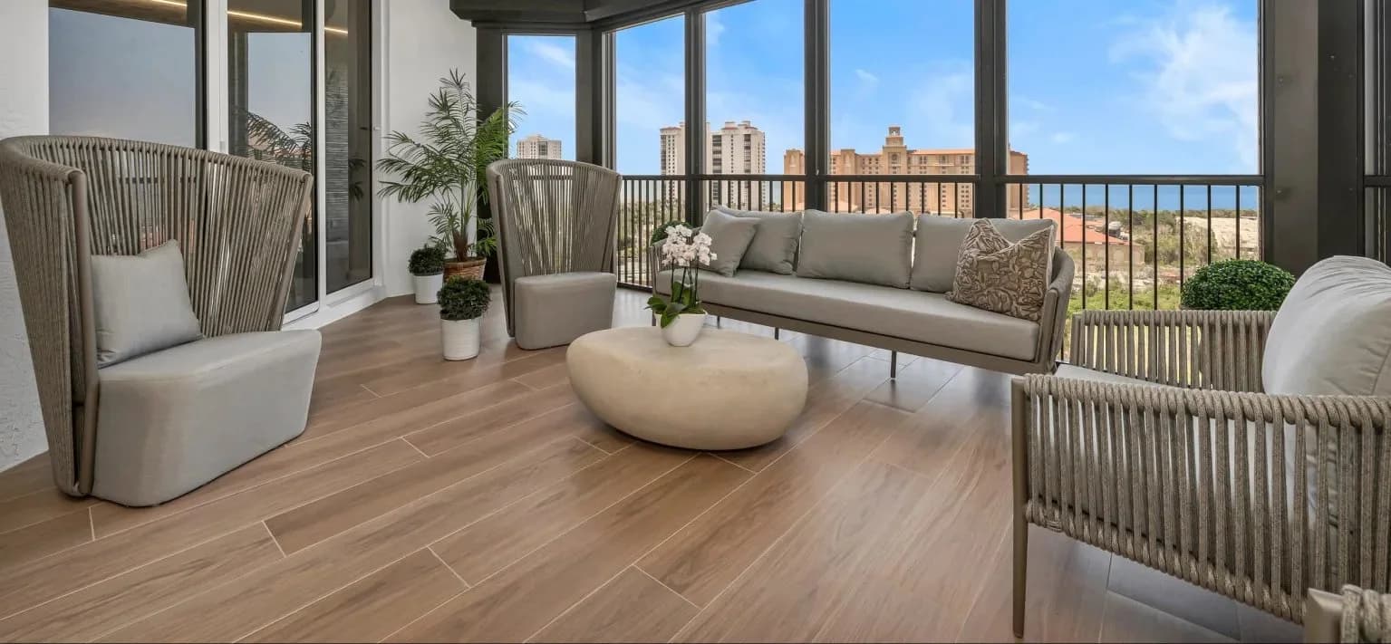 Bay Colony lanai with wide wood-look porcelain plank flooring opening to a Gulf view