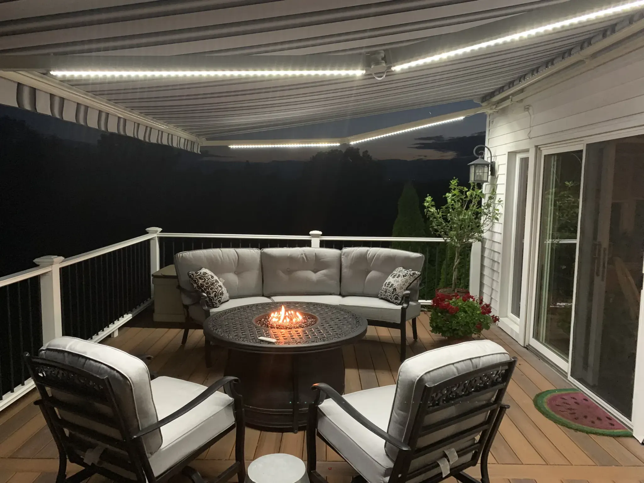 Integrated awning lighting illuminating an outdoor seating area at night