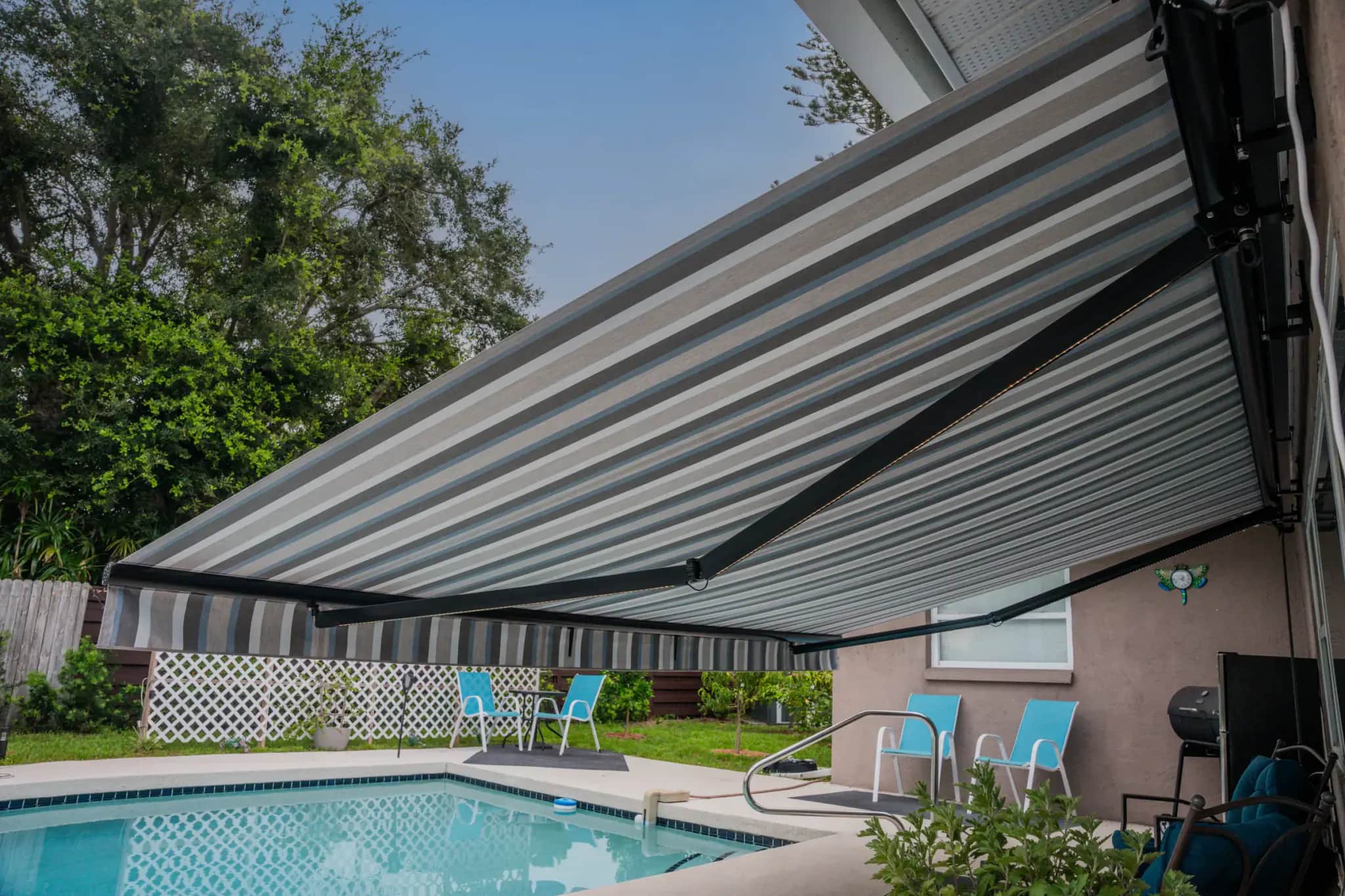 Semi-cassette retractable awning shading a residential pool deck