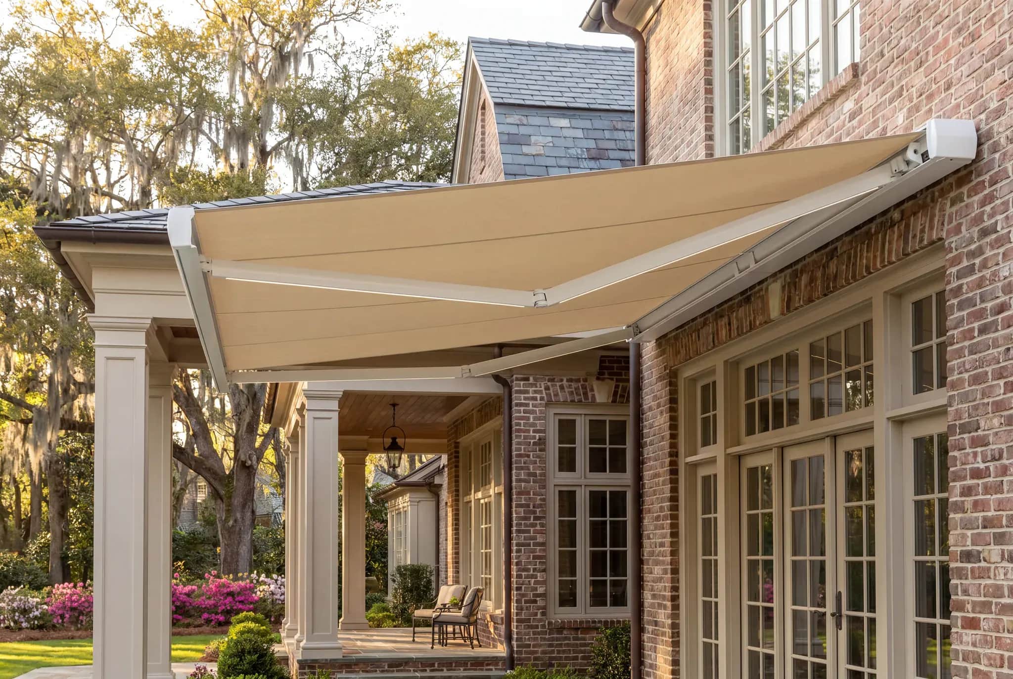 White full-cassette awning housing coordinated with a brick home and tan fabric