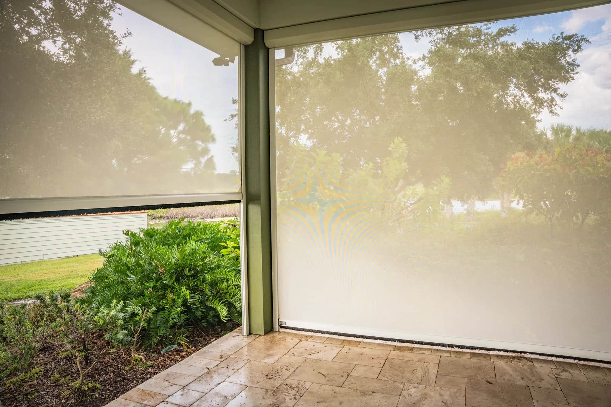 Installed SunPro privacy screens meeting at a finished porch corner