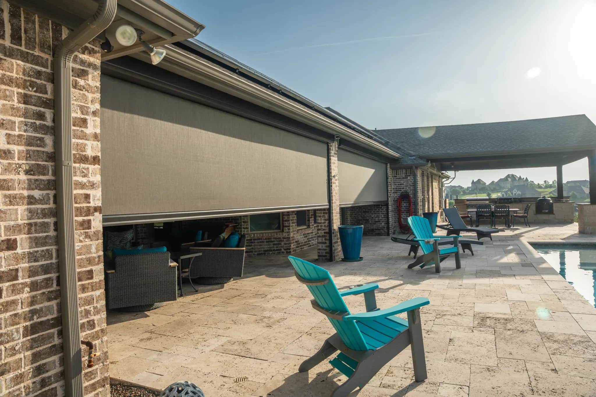 Solar screen fabric lowered across a poolside patio opening